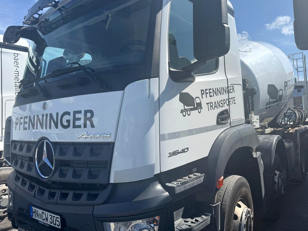 Weißer Mercedes Arocs Fahrmischer von Pfenninger Transporte mit Schriftzug PFENNINGER an der Front und Firmenlogo an der Tür